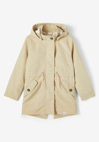Parka beige con capucha, botonadura frontal, cintura ajustable con cordón, y dos bolsillos con tapeta y botón, presentada sobre un fondo blanco.