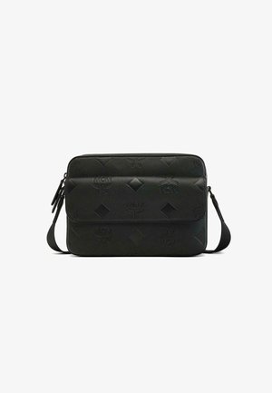 Czarna torba MCM z wytłoczonym logo, diamentowym wzorem i gładką teksturą. Posiada zamek błyskawiczny oraz regulowany pasek na ramię. Prostokątny kształt.