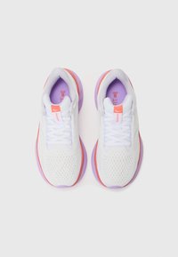 Baskets de sport blanches avec des accents violets et roses, dotées d'une tige en mesh respirant, de lacets plats et d'une semelle intermédiaire texturée.