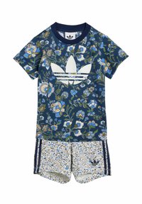 Completo in jersey con motivo floreale, composto da una maglietta blu navy con logo bianco e pantaloni corti a fantasia con sfondo chiaro e dettagli blu.
