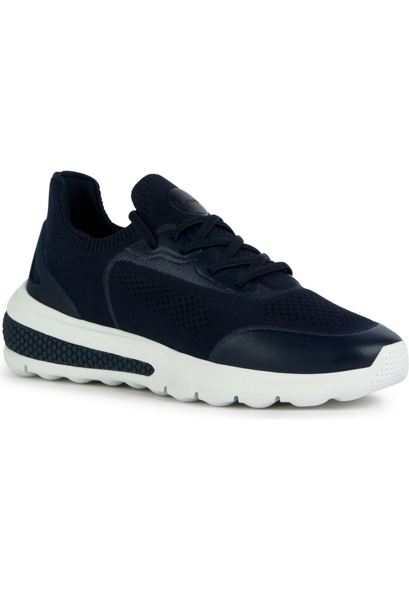 Zapatilla azul marino con parte superior de tela de malla, suela de goma, punta redonda y acentos texturizados en la entresuela para tracción.