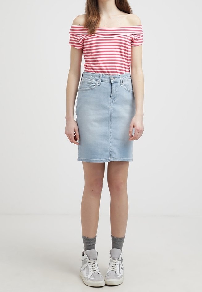 Světle modrá denimová sukně s rovnými liniemi, vysokým pasem a předními kapsami. V kombinaci s červeným a bílým pruhovaným topem bez raminek a teniskami.