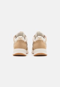 Béžové tenisky s hladkým designem z semiše a síťoviny, bílou mezipodešví a texturovanou gumovou podešví. Detail s logem na patě.