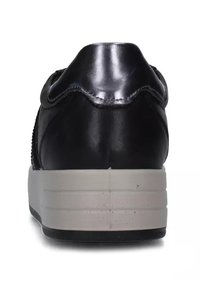 Sneaker in pelle nera con finitura testurizzata e bordi scallopati, caratterizzato da una spessa suola bianca e un design del tallone arrotondato.