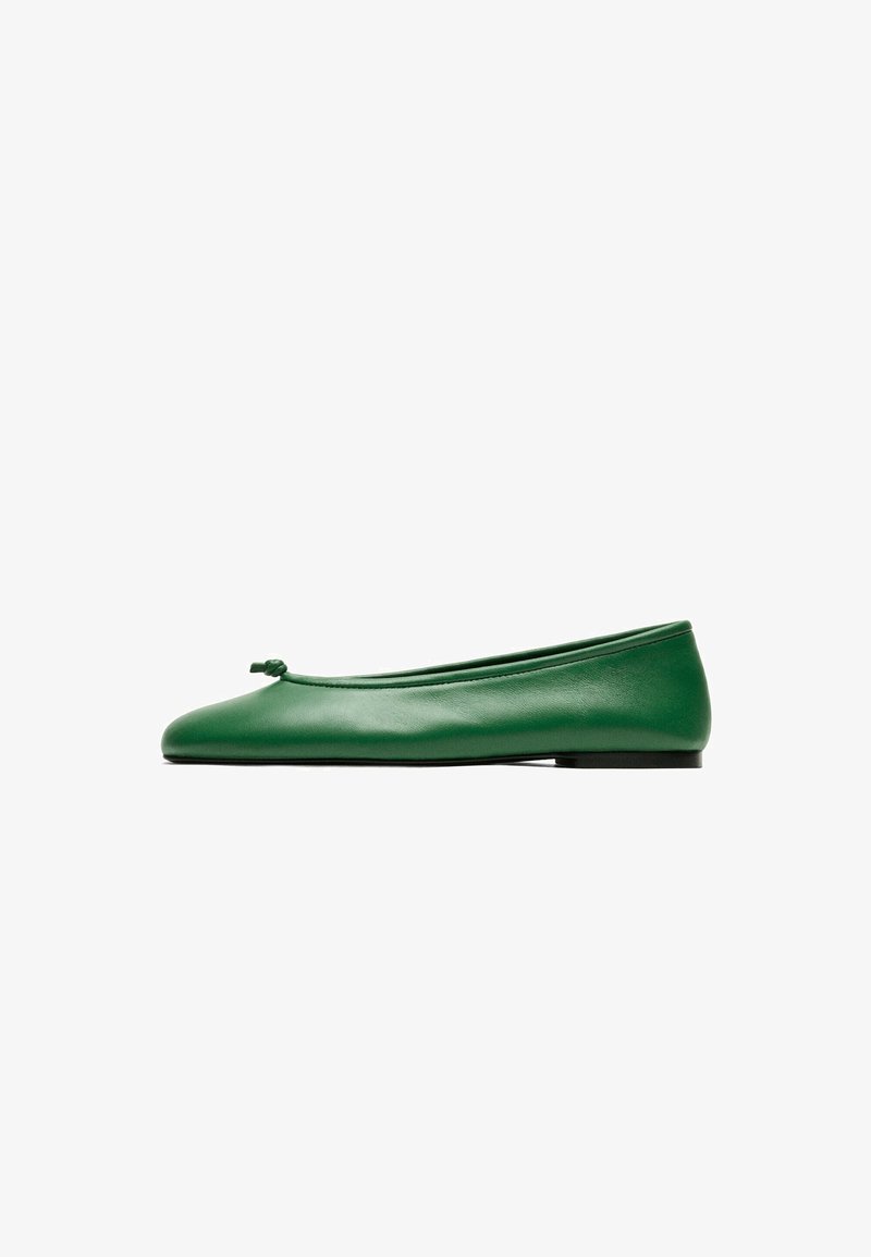 Green leather ballet flat with a small knot detail on the front and a flat black sole on a white background.