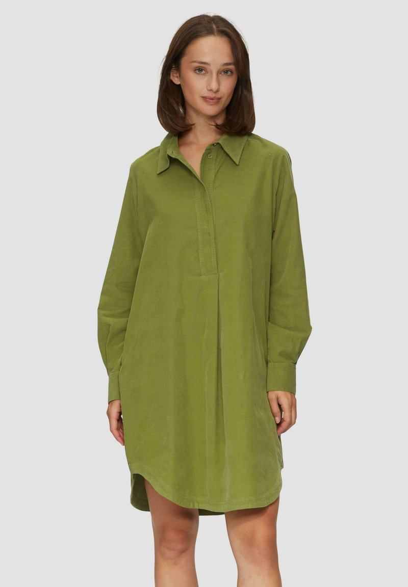 Grünes Cordhemdkleid mit einem kragenlosen Ausschnitt, langen Ärmeln und einer Vorderknopfleiste. Es hat eine lockere Passform und einen gerundeten Saum.