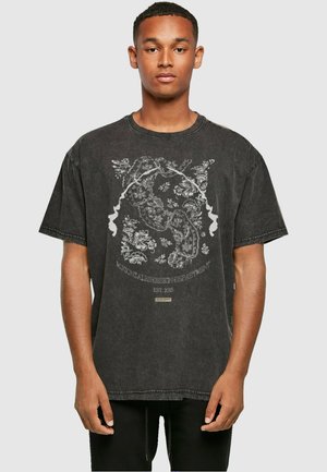 Sort oversized T-shirt med korte ærmer, prydet med et detaljeret hvidt blomster- og båndgrafik på forsiden, samt en rund halsudskæring.