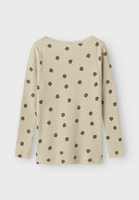 Langarmtop in zacht beige ribbelstof, met een kantafgewerkte halslijn en kleine donkere bloemenpatronen overal.