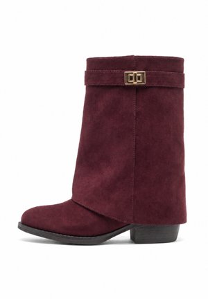 Dunkelvioletter Wildlederstiefel bis zur Mitte der Wade mit niedrigem schwarzem Absatz und dekorativer goldener Schnalle nahe dem oberen Rand.
