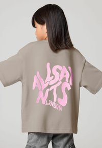 Šedé oversized tričko s velkým, nepravidelným růžovým grafickým textem "ALLSAINTS LONDON" umístěným na zádech uprostřed, krátké rukávy, bavlněný materiál.
