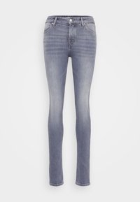Vaqueros ajustados en denim azul claro. Presentan un diseño clásico de cinco bolsillos, cremallera con botón y una textura ligeramente deslavada.