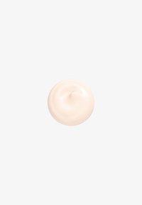 Wirbel aus hellbeiger Creme oder Lotion auf einem einfarbigen weißen Hintergrund, der eine glatte, kreisförmige Form mit einer zentralen Spitze bildet.