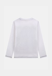 Camicia bianca a maniche lunghe con scollo rotondo. Presenta un tessuto texturizzato e cuciture nere a contrasto sui polsini e sull'orlo.