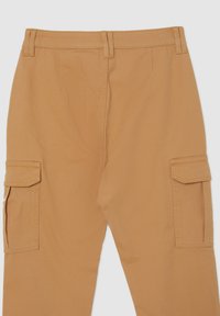 Pantaloni cargo in tessuto sabbia con taglio dritto, doppie tasche laterali e passanti per cintura. Texture liscia con cuciture minimali visibili.