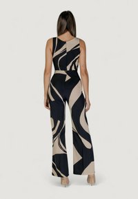 Tuta con corpino aderente, design a gamba larga e motivo astratto beige e blu navy. Realizzata in tessuto morbido e elasticizzato.