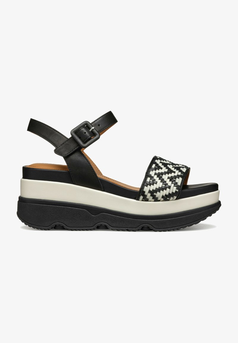 Zwarte platformsandalen met een geweven zwart-wit band, verstelbare enkelriem en een chunky bicolor zool. Textured rubberen loopvlak.