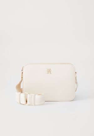 Cremefarvet rektangulær crossbody-taske med justerbar stofrem og lille gyldent dobbelt-T-logo foran.
