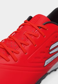 Φωτεινό κόκκινο αθλητικό παπούτσι με κορδόνια στο ίδιο χρώμα, διάτρητο επάνω μέρος, μαύρο επενδεδυμένο κολάρο και ασημένιο λογότυπο στο πλάι με την επιγραφή SKX:FT8L.