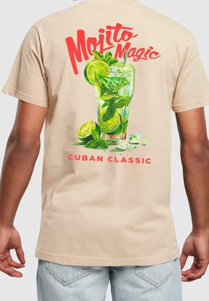 Beige t-shirt featuring a vibrant graphic of a mojito glass, lime slices, and mint. Text reads "Mojito Magic" and "Cuban Classic."