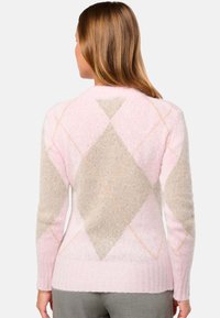 Pull en couleur rose et beige avec un motif argyle en tricot doux et texturé, à manches longues et ourlet côtelé, mettant en avant des accents orange clair.