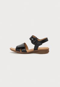 Black leather sandals with a buckle and side strap, flat sole, open-toe design, and textural detail on the upper flap.