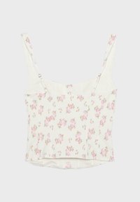 Crop top blanc avec fines bretelles réglables, imprimé floral rose et légère encolure en cœur.