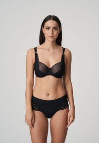 Czarny koronkowy stanik z przezroczystymi miseczkami i regulowanymi ramiączkami; pasujące czarne majtki high-waisted z koronkowym wykończeniem na brzegach.