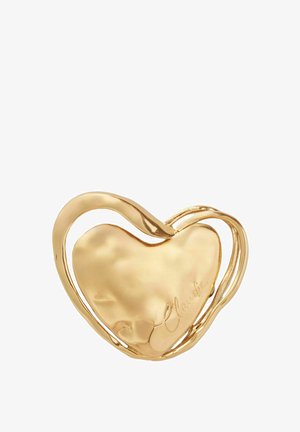 Pendentif en or en forme de cœur avec une surface lisse et des accents entrelacés. Présente le texte gravé "Claudie" d'un côté.