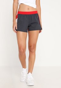 Grau Athletikshorts mit rohem elastischem Taillenbund, seitlichen Einsätzen und Logodetail. Hergestellt aus leichtem, atmungsaktivem Material für hohen Tragekomfort.