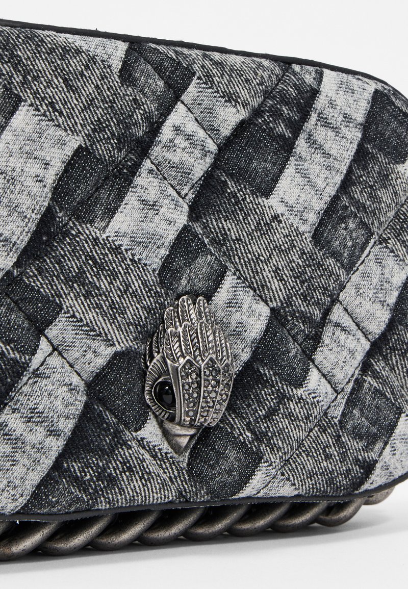 Gequiltete schwarze und graue Textil-Handtasche mit einem dekorativen metallischen Handverschluss und einer strukturierten geflochtenen Kette.