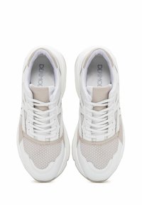 White sneakers with beige accents, mesh panels, and rubber soles. Features lace-up design and padded collar for comfort.