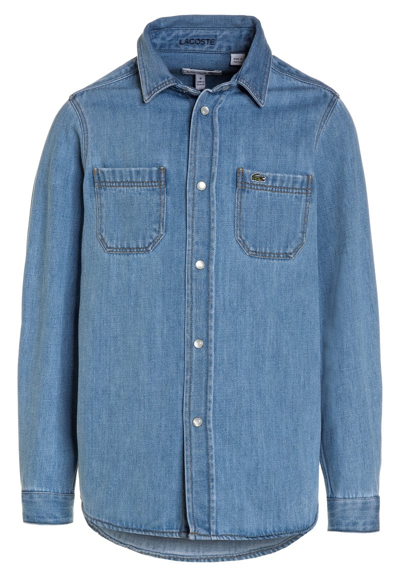 Jasnoniebieska koszula dżinsowa z zapięciem na guziki z przodu, dwiema kieszeniami na piersiach oraz logo Lacoste na lewej kieszeni. Długie rękawy z guzikami przy mankietach.