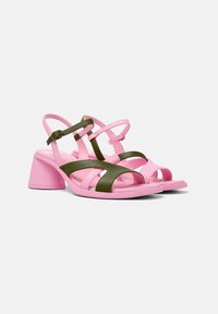 Pink and green sandals with a block heel, featuring multiple straps and an open toe design, created from smooth synthetic material.