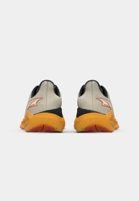 Laufschuhe mit einem hellgrauen Obermaterial, schwarzen Akzenten und einer leuchtend orange-roten Sohle. Merkmale sind ein strukturiertes Material und ein elegantes, modernes Design.