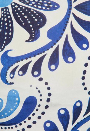 Motif floral bleu et marine avec des formes en goutte et des points sur fond blanc, ressemblant à des pétales et des vignes stylisés.