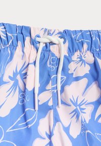 Blå blommiga badshorts med vit dragsko, elastisk midja och stora ljusrosa hibiskusmönster på tyget.