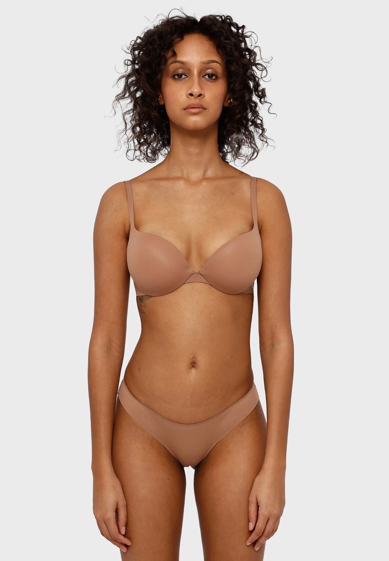 Hellbeige Push-Up-BH mit glatten Cups und verstellbaren Trägern. Passende Bikini-Unterhose mit minimaler Bedeckung. Weicher, nahtloser Stoff überall.