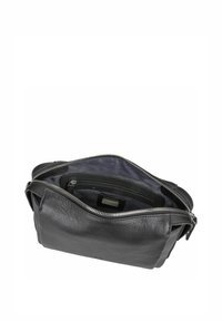 Schwarze Lederhandtasche mit strukturierter Oberfläche, mit Reißverschluss, einem Innenfach und einem weichen Stofffutter, von oben betrachtet.