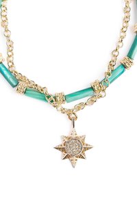 Collana in tonalità oro con perline cilindriche in turchese, separatori dorati e un pendente a stella con centro scintillante e design intagliato.