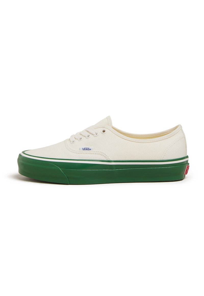 Sneaker in tela color avorio con suola in gomma verde, lacci bianchi e logo sottile. Presenta una punta rotonda e una striscia verde a contrasto.