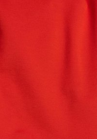 Silek merah yang halus dengan bayangan yang lembut dan tekstur tenunan yang halus ditampilkan dalam dekat.
