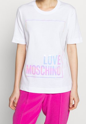Camiseta de algodón blanca con mangas cortas, que presenta una impresión brillante de "LOVE MOSCHINO" en tonos de azul y rosa dentro de un borde rectangular.