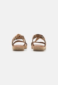 Tan espadrille-sandaler med leopardmønstrede stropper, åben bagdesign, syede kanter og jute-indpakkede såler. Glat indersål synlig.