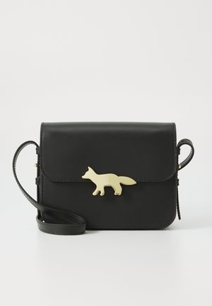 Schwarze Leder-Crossbody-Tasche mit umklappbarem Deckel, ausgestattet mit einem goldenen Verschluss in Form eines Fuchses und einem Schultergurt. Glatte Textur und kompaktes Design.