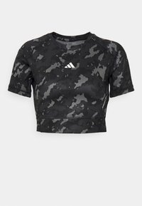 Černé sportovní tričko s krátkým rukávem a maskáčovým vzorem, vyrobené z hladké látky, s malým bílým logem na hrudi a krátkým střihem.