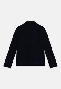 Černý upravený kabát s klopeným límcem, strukturovaným designem a dlouhými rukávy. Obsahuje čtyři knoflíky na každém manžetě a hladkou texturu.