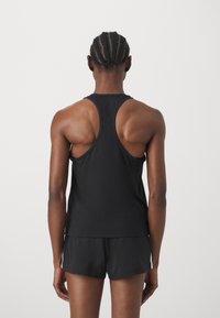 Tricou sport negru fără mâneci cu un design racerback, prezentat din spate. Material neted și croială lejeră, combinat cu pantaloni scurți asortați.