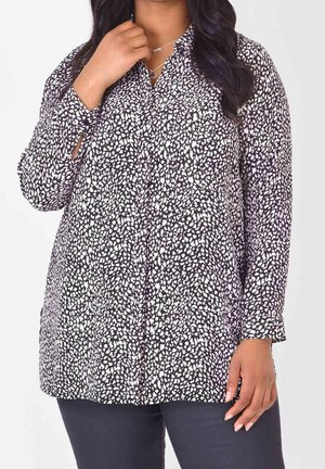 Blusa a maniche lunghe con bottoni in pattern a pois bianchi e neri. Presenta un colletto e una vestibilità comoda, realizzata in tessuto morbido.