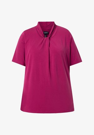 Blouse manches courtes magenta avec encolure haute froncée et coupe ample.