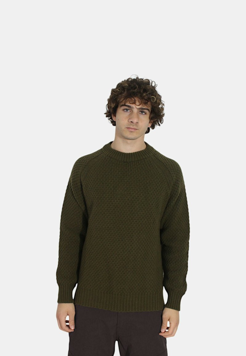 Maglione lavorato a maglia verde oliva con un motivo testurizzato, colletto a girocollo a coste e maniche lunghe raglan, abbinato a pantaloni scuri.